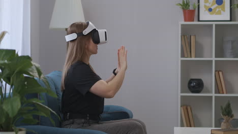 woman-with-head-mounted-display-is-having-fun-at-home-at-weekends-viewing-pictures-or-video-zooming-and-swiping-virtual-screen